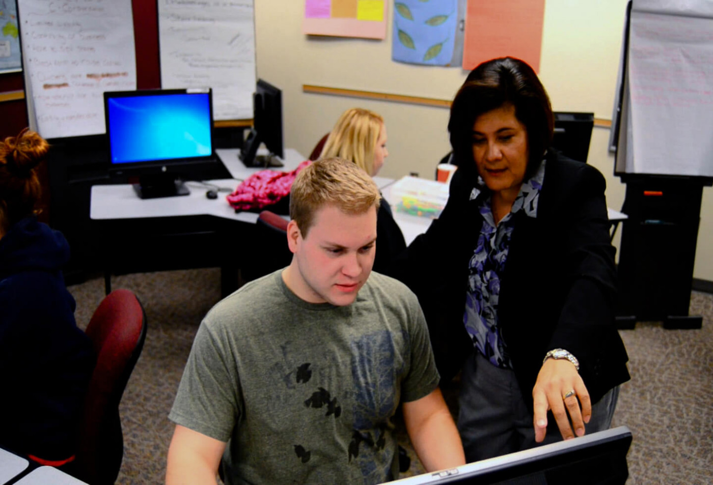 Instructor advising student over computer