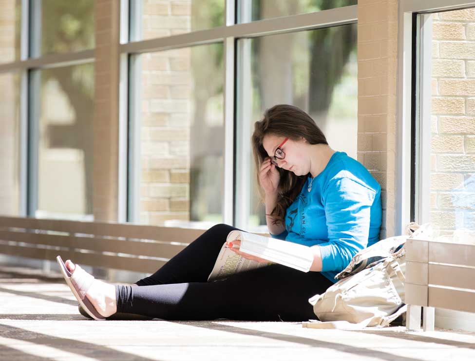 Student studying on floor of campus building