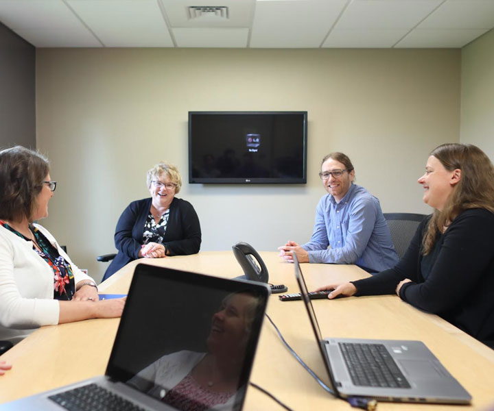 Four people in conference meeting