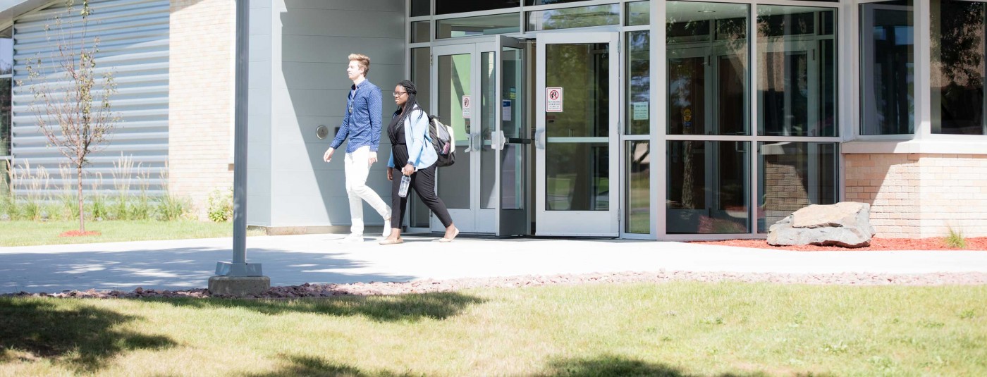 Two students walking outside campus building