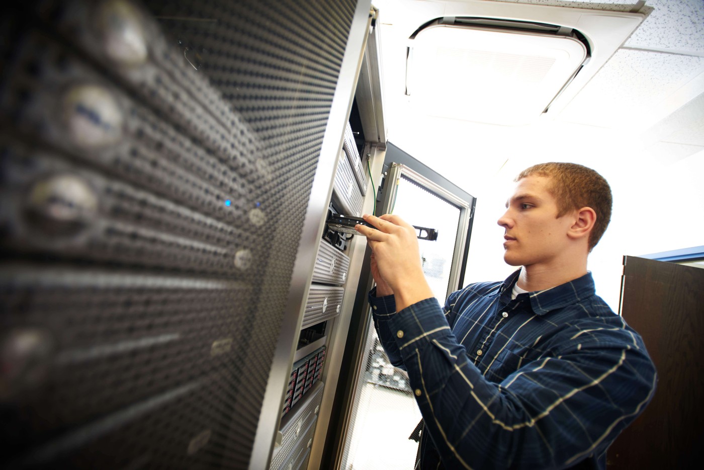 IT - Networking Specialist - standing near server rack