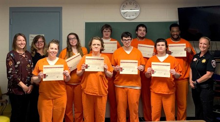 Inmates smiling with achievement awards