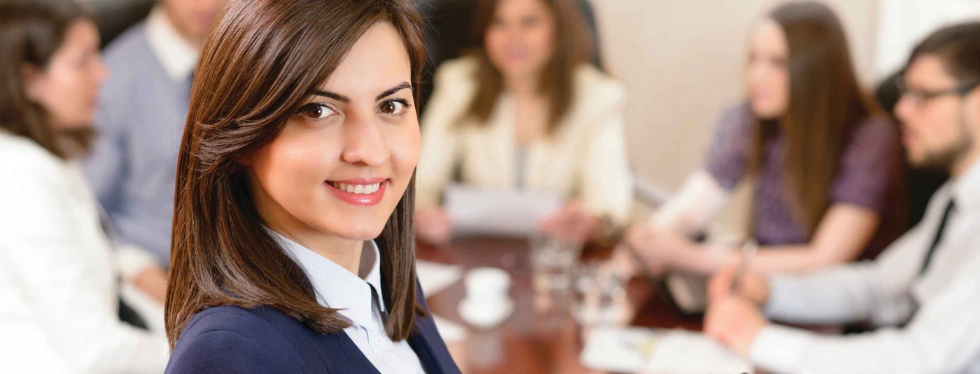 Professionally dressed person smiling at conference meeting