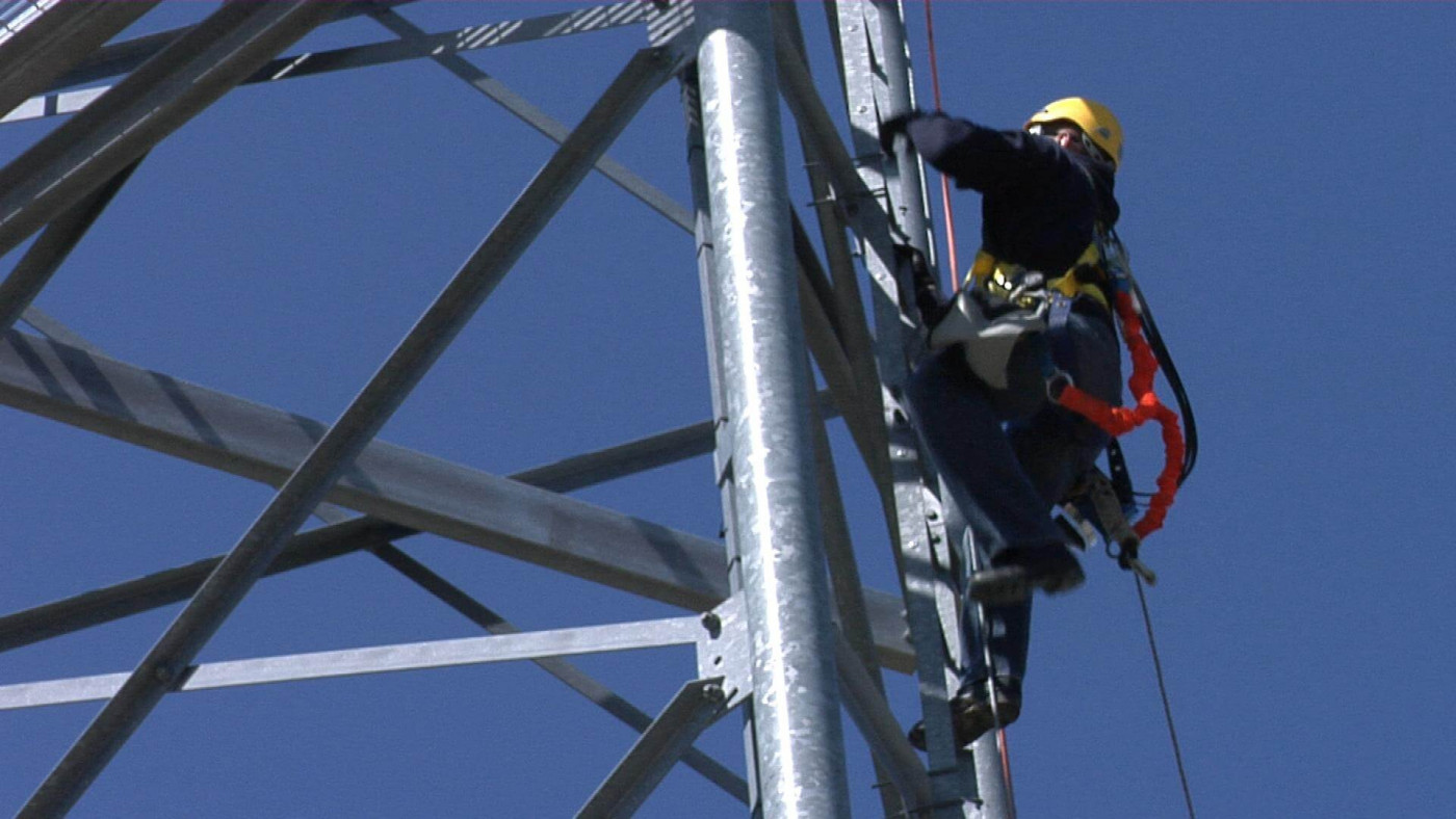 Technician climbing up a wind turbine