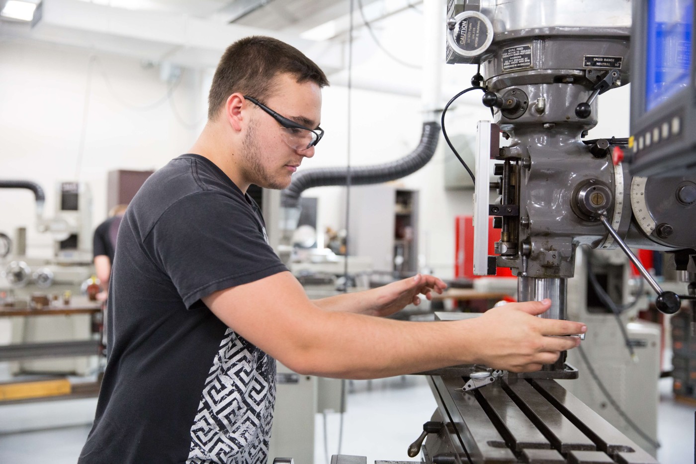 Young man working on a CNC machine