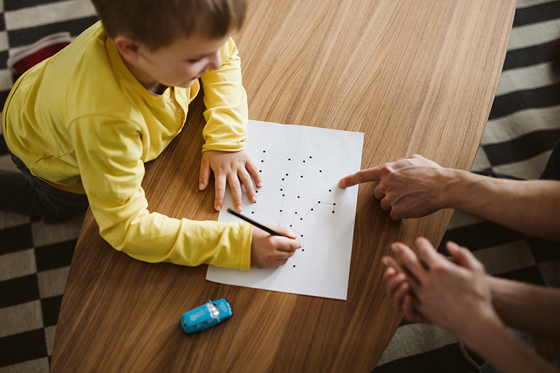 Clinician working with child on completing tasks