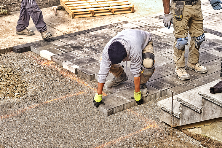 Landscape technicians working with brick pavers