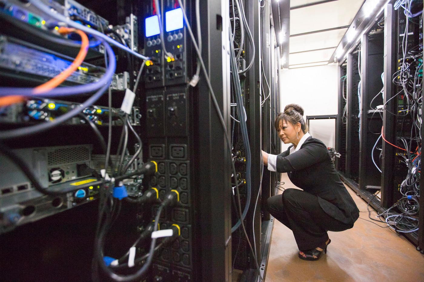 Woman working on network server racks