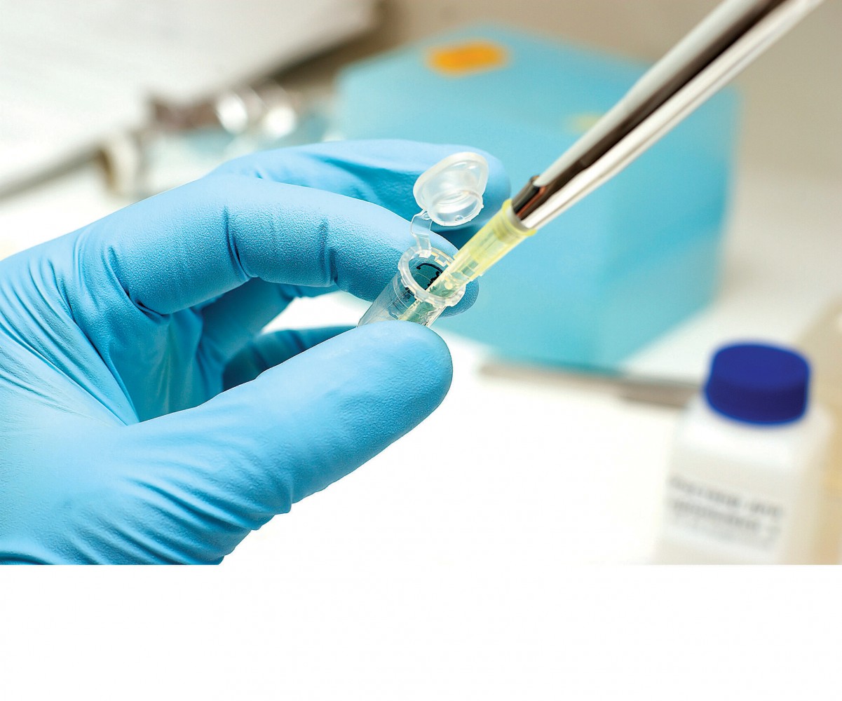 Close up image of bio-technician using syringe