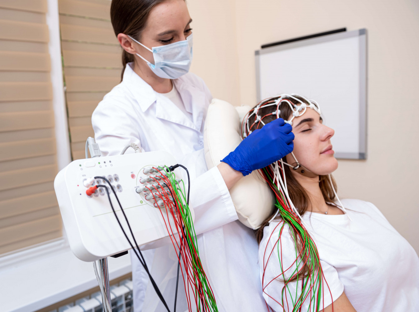 Neurodiagnostic technician fitting cap on patient